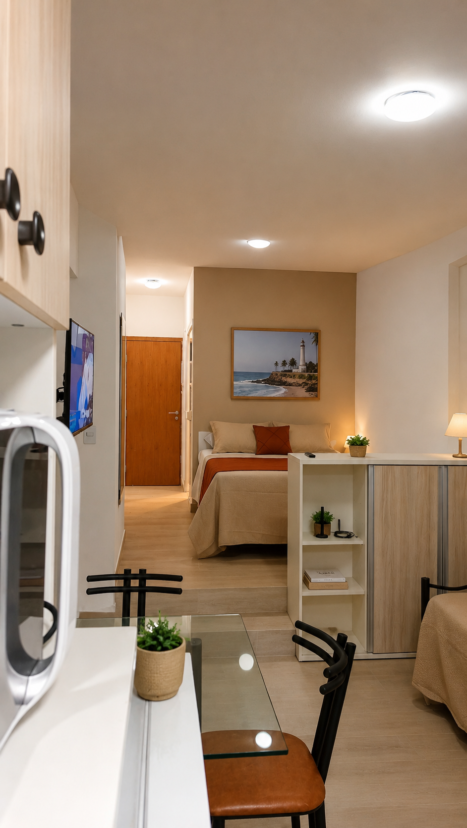 Apartamento studio do Bahia Flat na Barra, Salvador, com cama de casal, cozinha equipada, mesa de refeições e ambiente moderno e aconchegante.